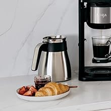 Thermal carafe with croissants jam and berries