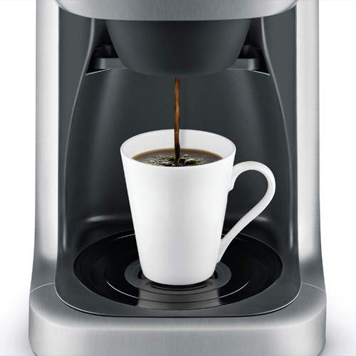 Coffee brewing directly into a travel mug.