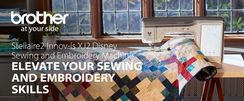 Headline:  Stellaire2 Innov-&#237;s XJ2 Disney Sewing and Embroidery Machine Subhead: ELEVATE YOUR SEWING AND EMBROIDERY SKILLS; Image of machine in room setting with large quilt 