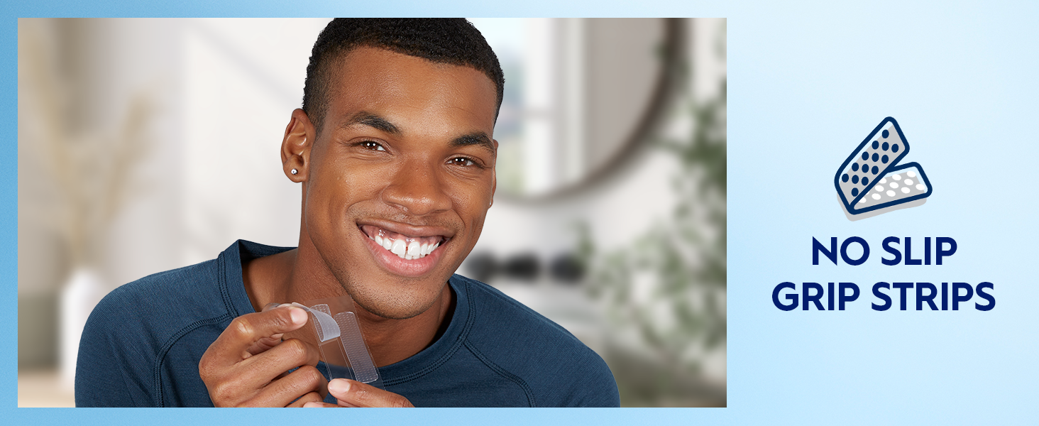 A man smiles bright while holding up a Crest 3DWhitestrips strip. Claim reads: No Slip Grip Strips.