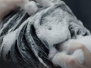 Zoomed picture of short dark hair being washed.