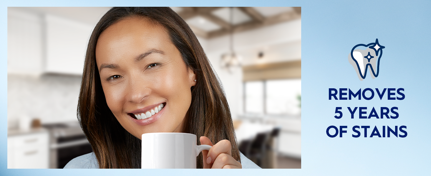 A woman smiles bright while holding up a white coffee mug. Claim reads: removes 5 years of stains.