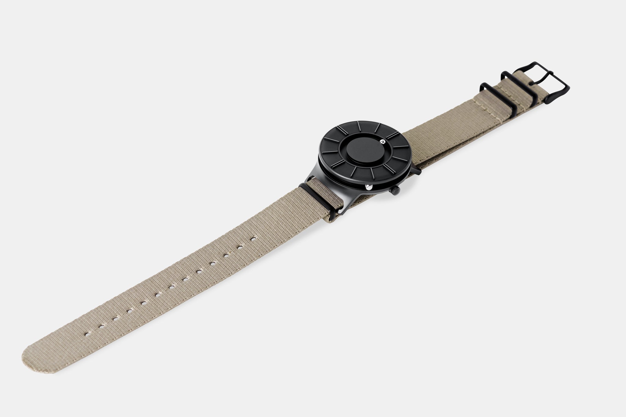 A photo of the watch lying flat on a surface. The recessed track around the outside of the watch face is shown with the hour ball bearing in the track. The raised markers are noticeable from this perspective.