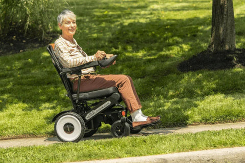 Senior woman using Move Lite Folding Power Wheelchair, illustrating effortless mobility with adjustable controls.