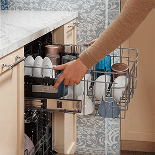 A user easily lowers their loaded upper rack with the press of a button to accommodate taller items.