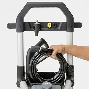 A person placing the pressure washer hose into the accessory storage