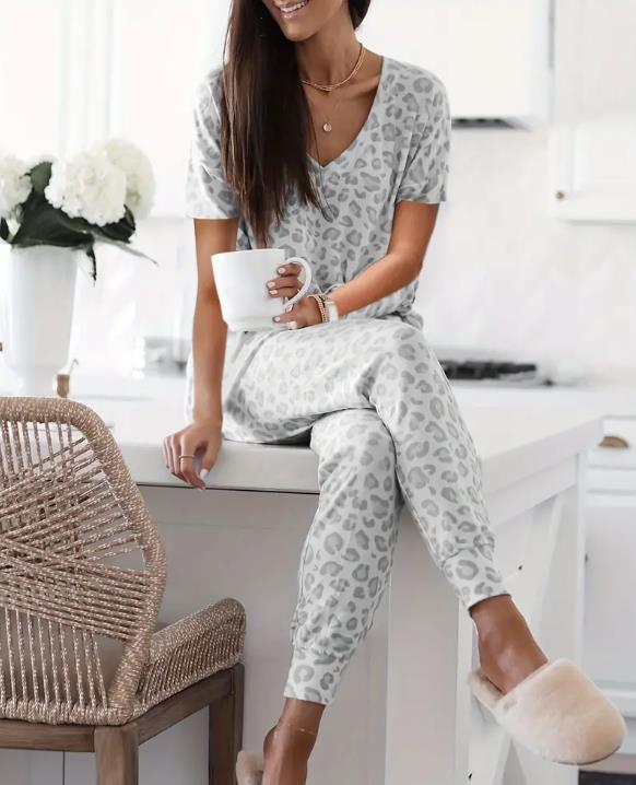 Women's V-NeckLeopard Print Loungewear Set. This relaxed-fit two-piece features a short-sleeve top and pants for effortlessly chic, casual comfort.