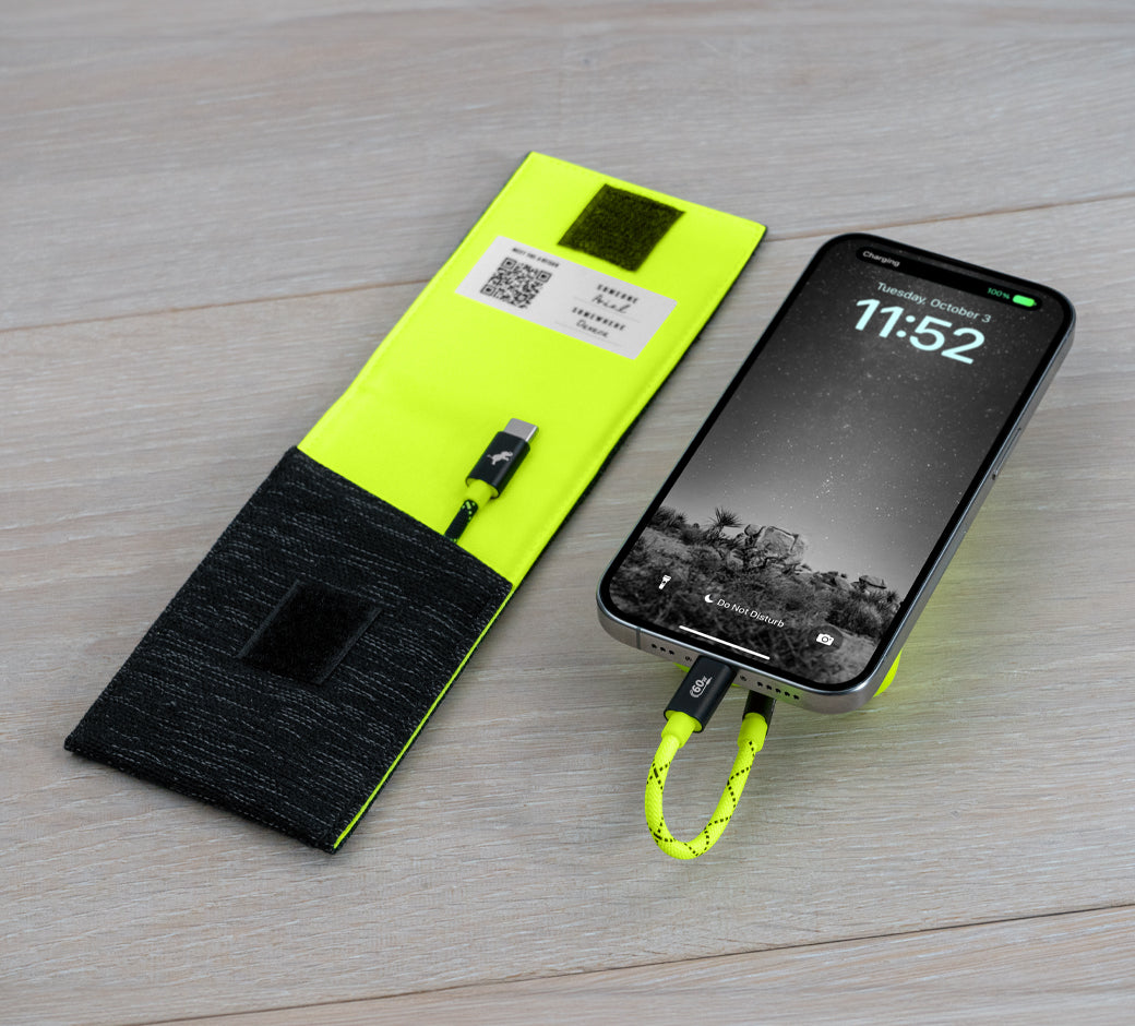 Neon yellow case with a charging cable next to a phone showing 11:52 on the screen.