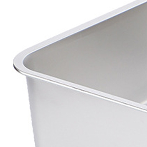 Close-up of a stainless steel container corner, showing smooth curved edges and a matte interior surface.