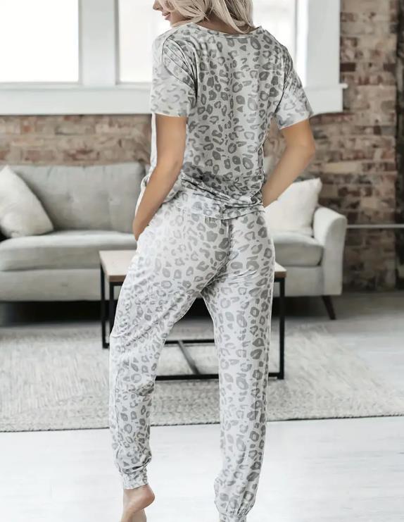 Women's V-NeckLeopard Print Loungewear Set. This relaxed-fit two-piece features a short-sleeve top and pants for effortlessly chic, casual comfort.