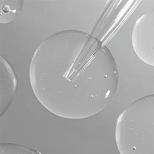 Drops of purifying formula with a pipet on a gray background.