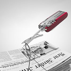 Scissors from a pocket knife cutting a cord keeping newspaper together