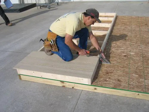a man assembling the pre-cut walls of a Little Cottage Co storage shed