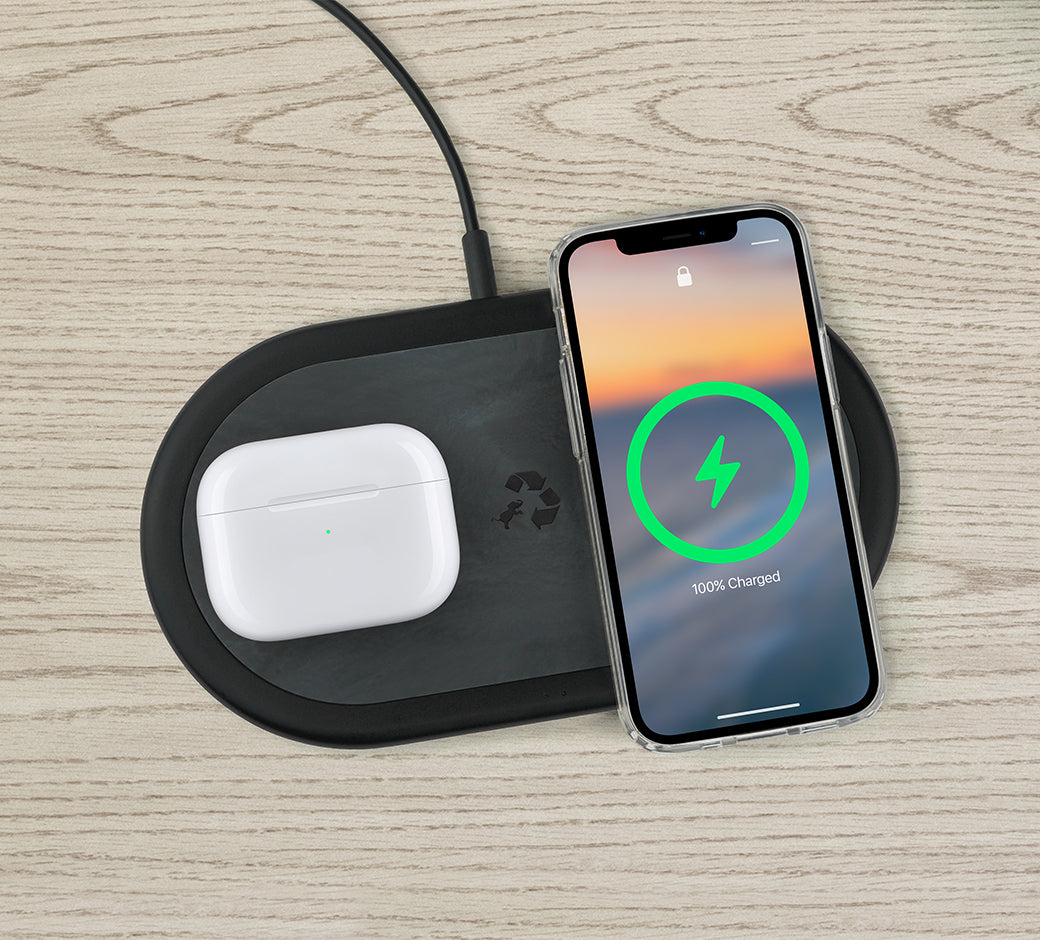 Charging pad on a table with a smartphone (100%) and AirPods charging.