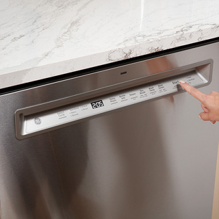 A user presses start on the control panel of the dishwasher to demonstrate the reliable performance of the unit.