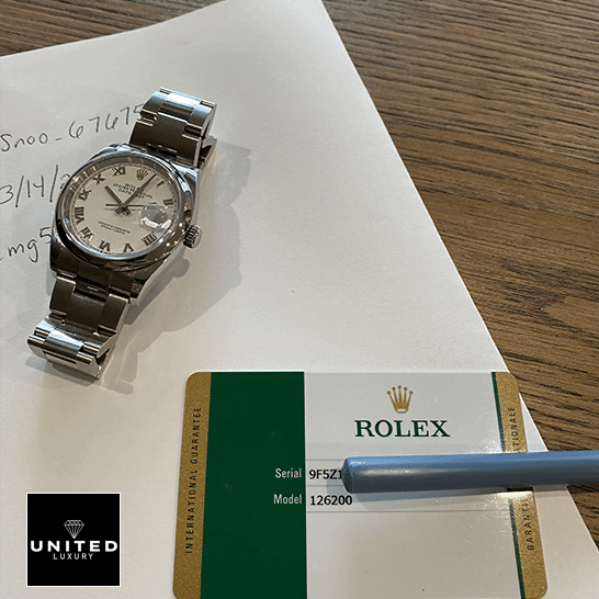 Rolex datejust Replica watch and warranty card on the table