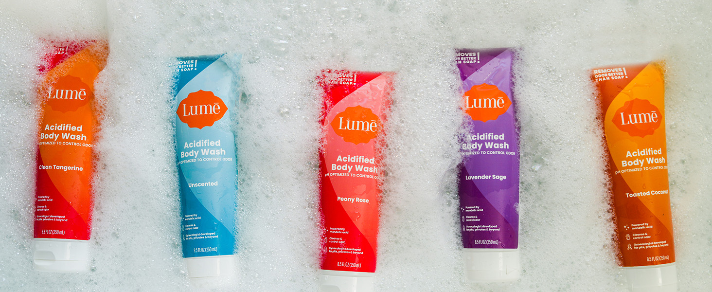 Lumē Acidified Body Wash in available scents floating in a bath tub