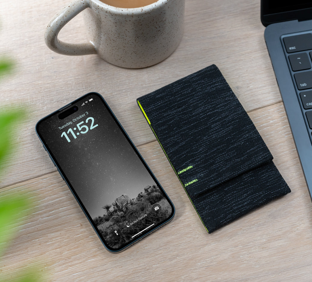 Phone on a desk beside a black Nimble pouch, laptop, and coffee mug.