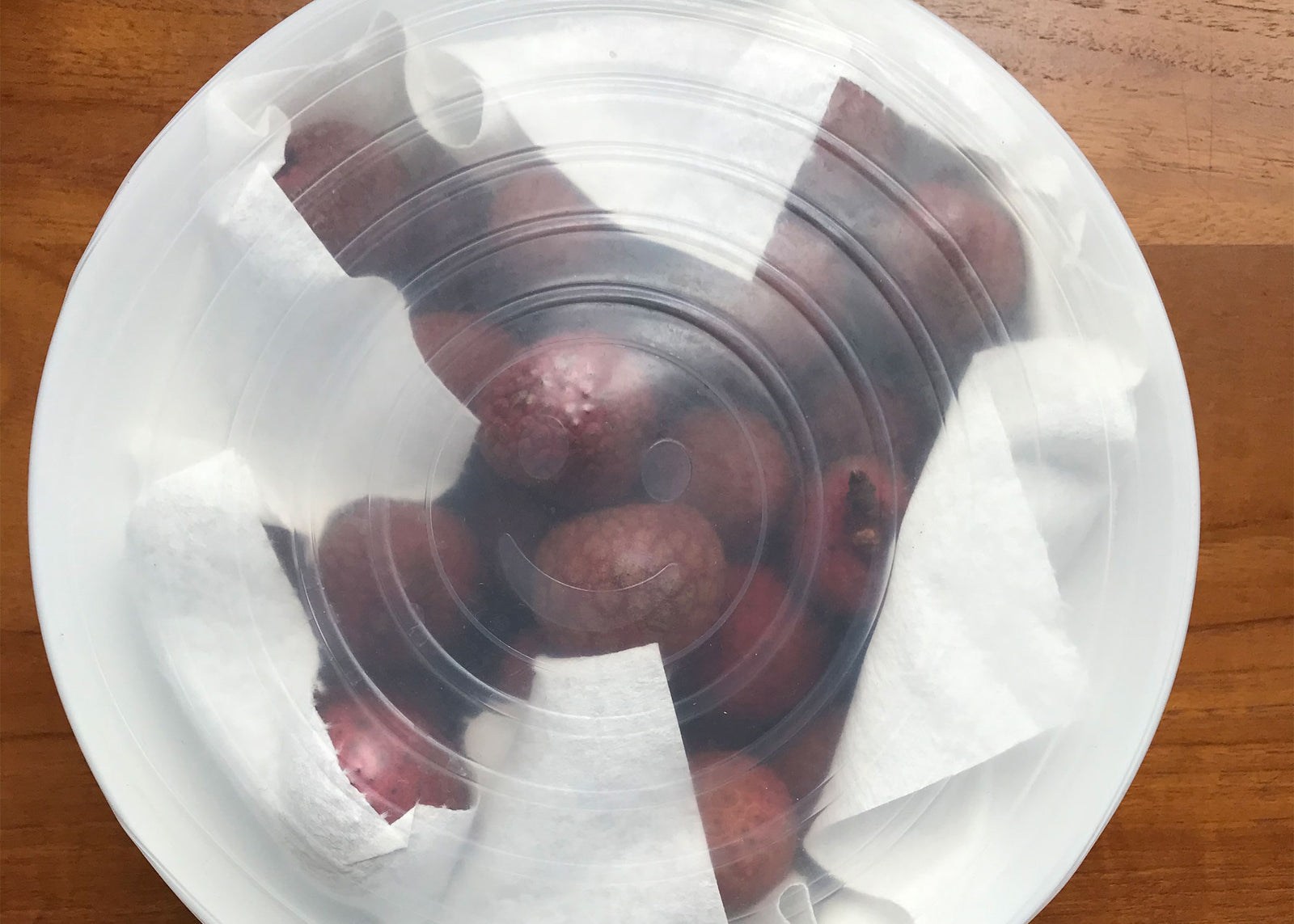 Lychee in bowl with plastic covering for storage.