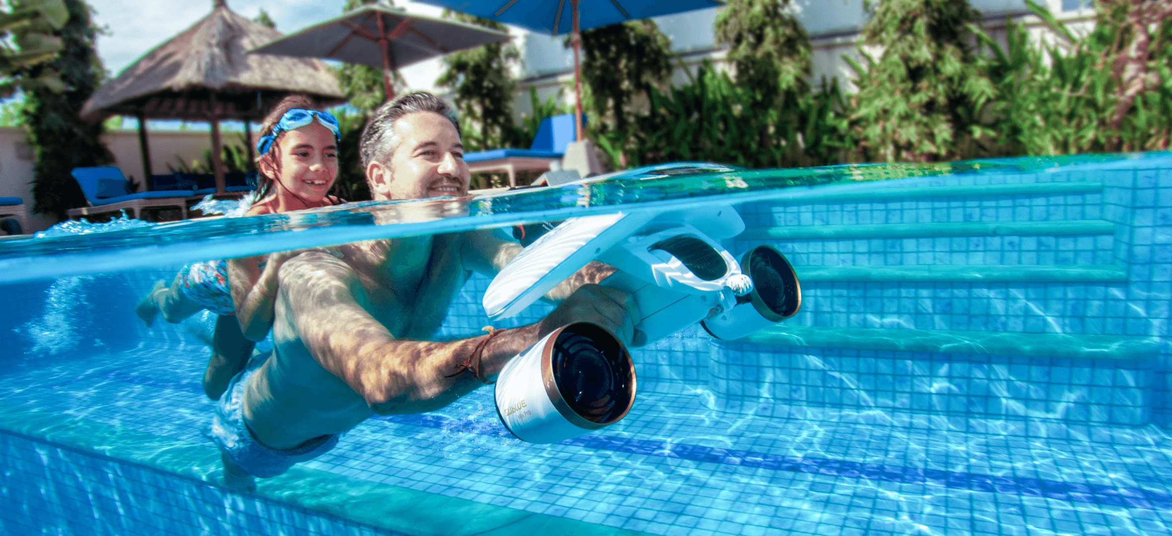 a man and woman swimming in a pool with a toy