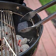 adding charcoal to weber grill with hinged cooking grate