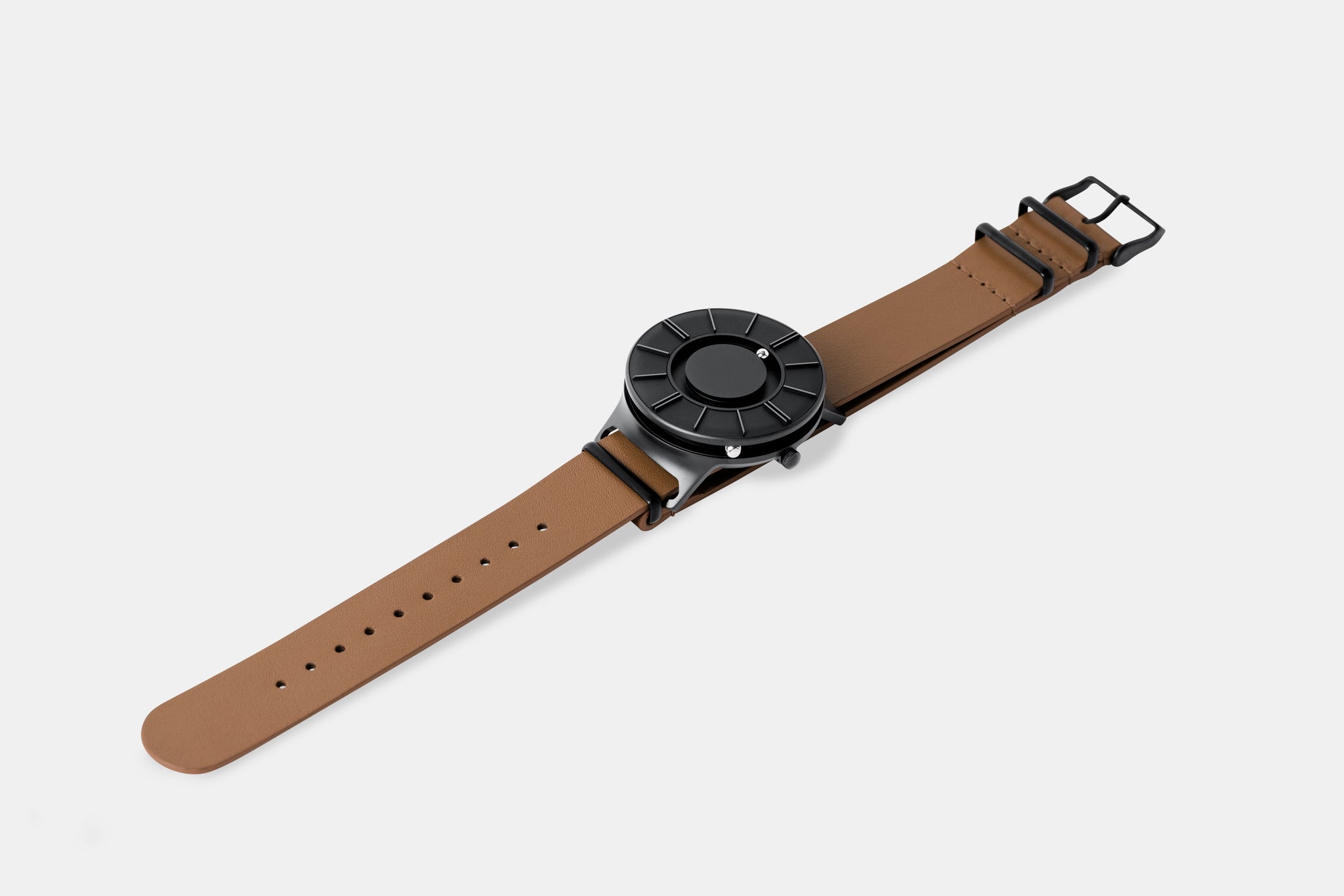 A photo of the watch lying flat on a surface. The recessed track around the outside of the watch face is shown with the hour ball bearing in the track. The raised markers are noticeable from this perspective.