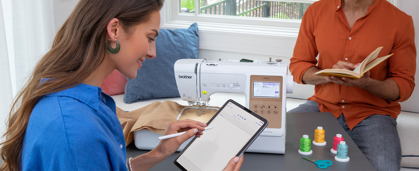 Woman using Artspira app on mobile tablet to draw custom embroidery design for Brother LB5500
