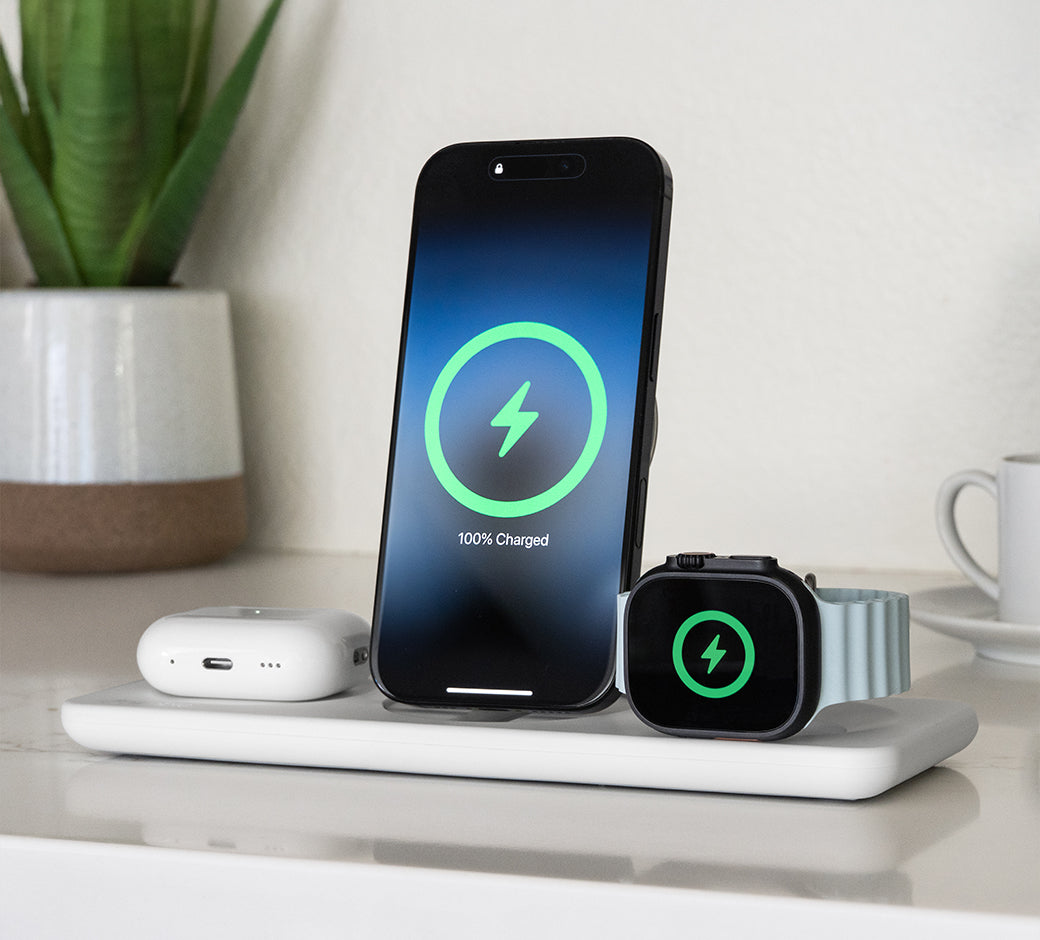 Phone and watch on a charging dock showing the battery status.