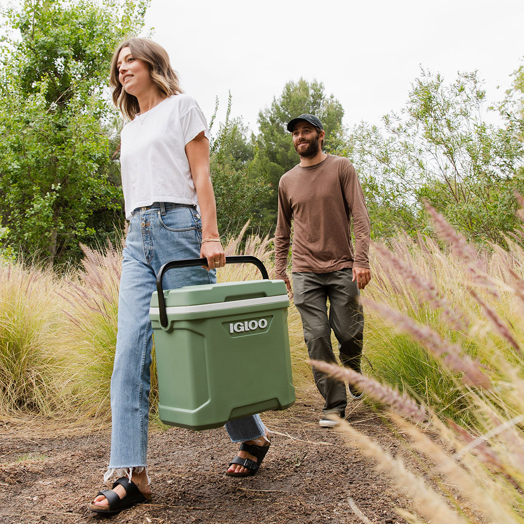 Kid putting a water bottle in the 30 quart cooler at the park