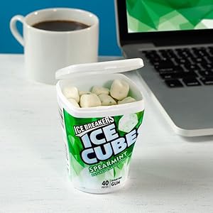 Ice Breakers Ice Cubes spearmint flavored gum on a desk with a cup of coffee and laptop