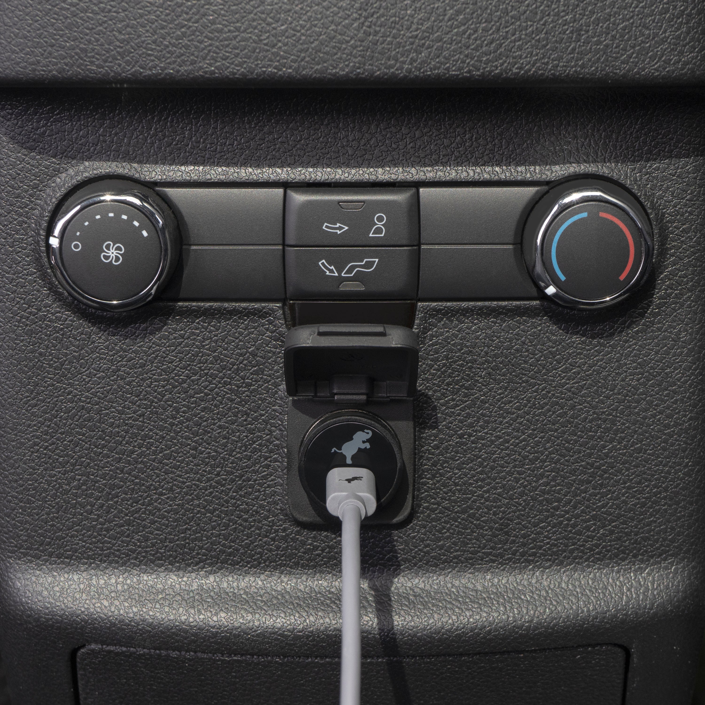 Grey USB car charger plugged into a car's power outlet.