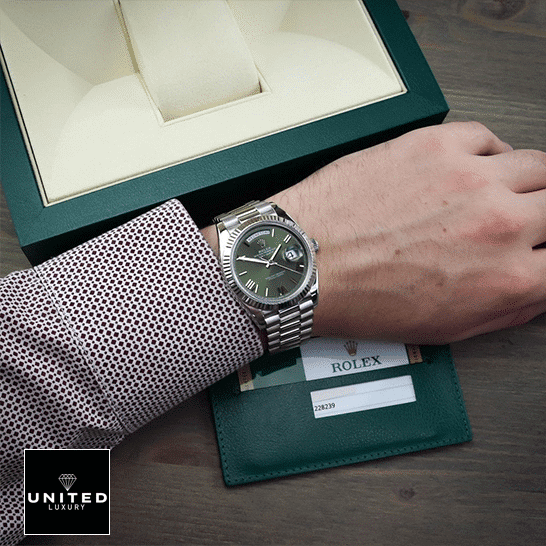Rolex Day-Date Olive Green 228239 Replica Rolex Box in front of on is arm